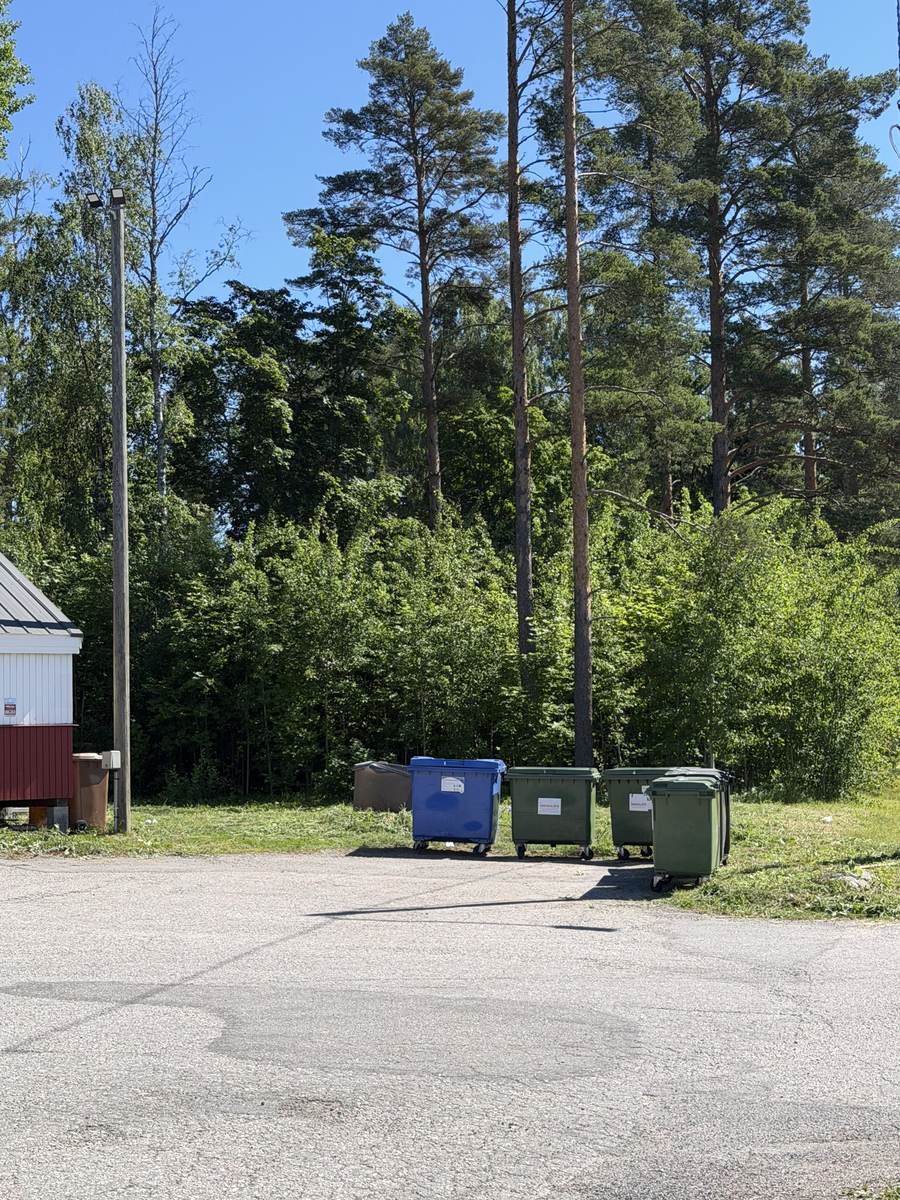 Siisti, trimmattu alue jäteastioiden ympärillä Espoossa